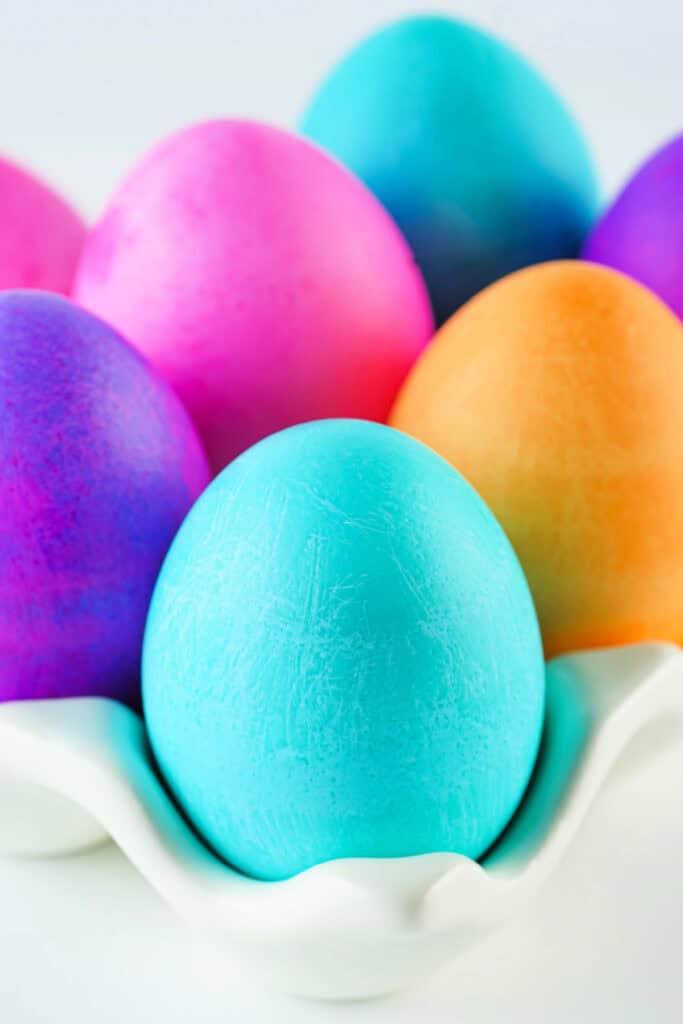 assorted colors of food dyed easter eggs in carton