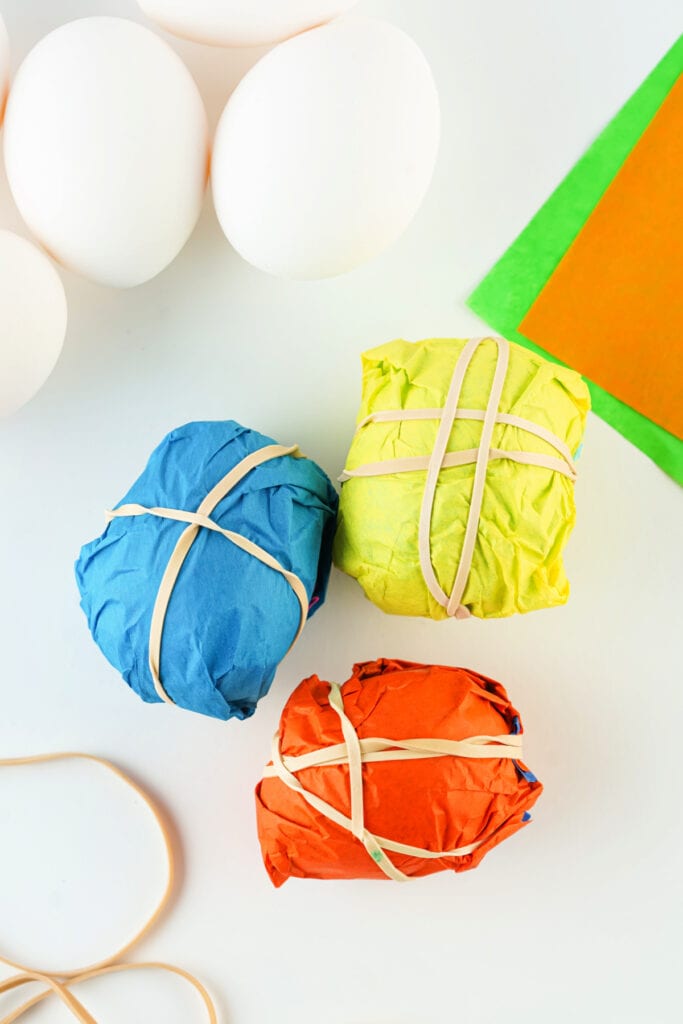 assorted colors of tissue paper wrapping hard boiled eggs