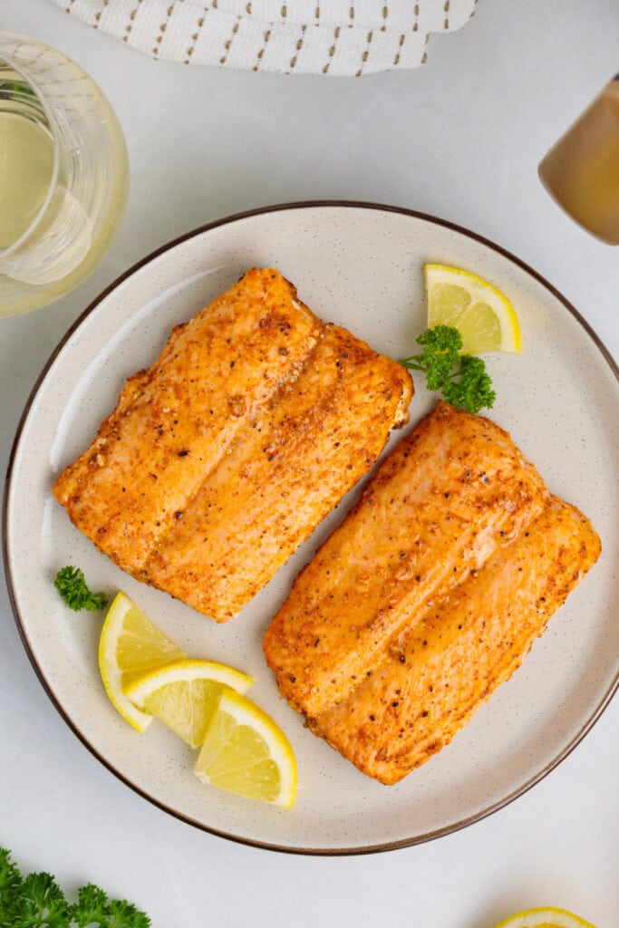 two pieces of Air Fryer Frozen Salmon on a plate after being cooked