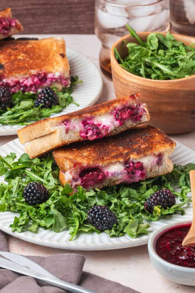 Blackberry grilled cheese sandwiches served on arugula with fresh blackberries and iced drinks