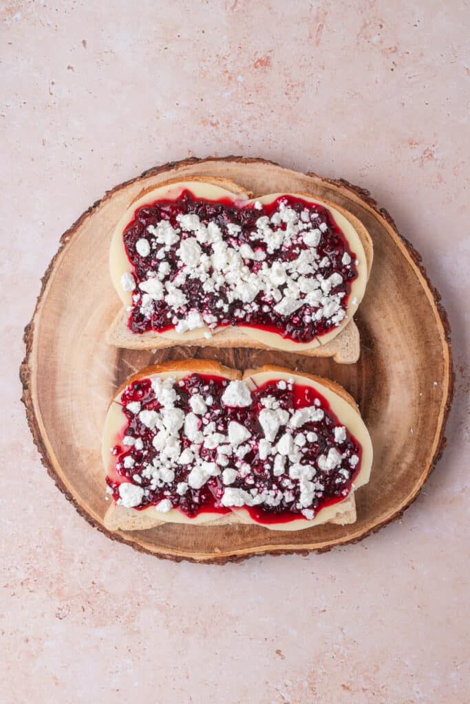 Blackberry jam layer topped with crumbled goat cheese on the sandwich base