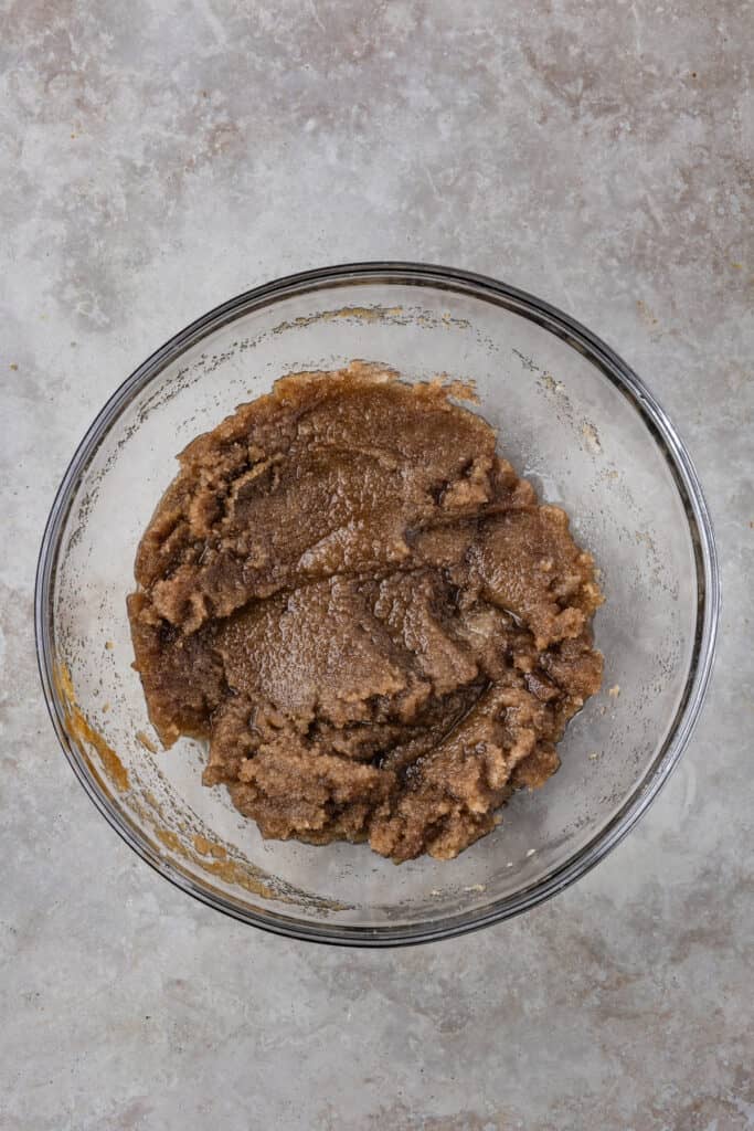 Brown sugar and butter mixture in a glass bowl after being combined and partially creamed.