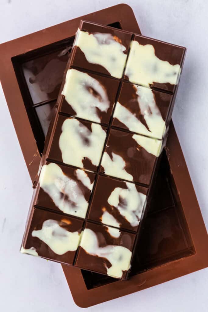 Unmolded Dubai Chocolate Bar showing a glossy chocolate shell with white decorative swirls.