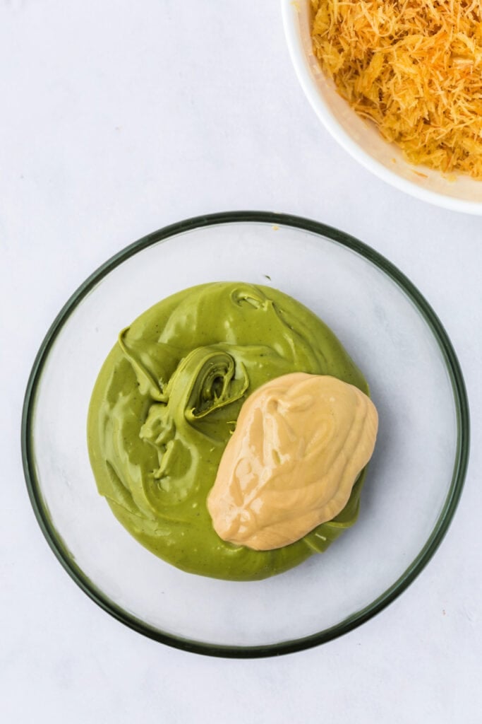 A bowl of pistachio butter and tahini side by side, ready to be mixed, with toasted kataifi in background.