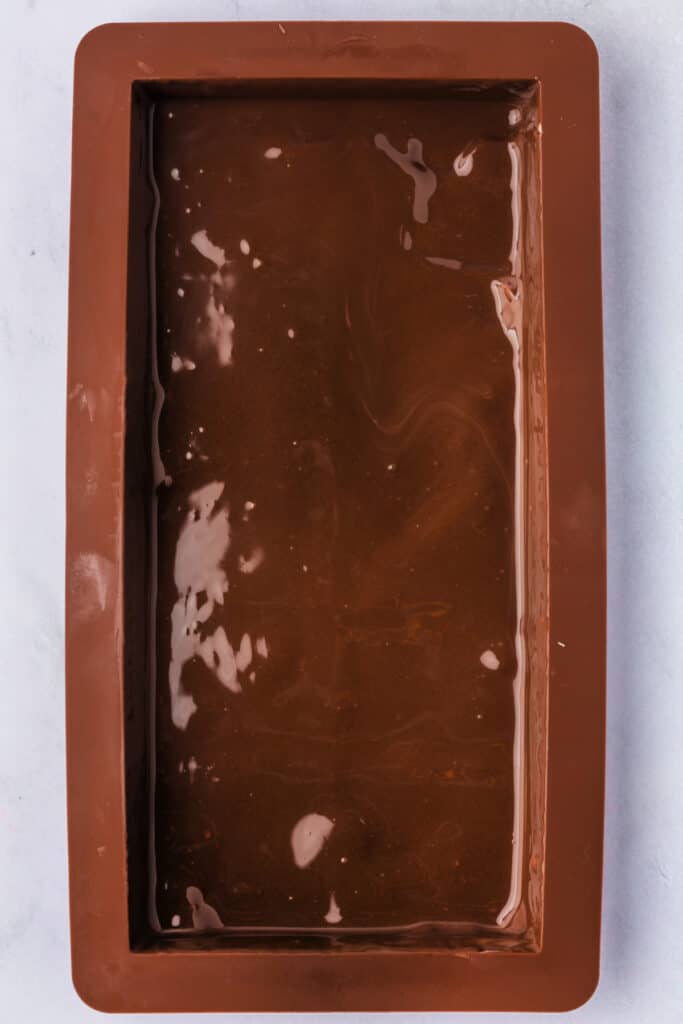 Mold filled with smooth melted chocolate coating the base and sides evenly.