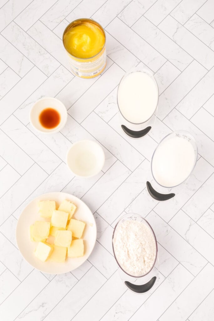 Overhead view of Easy Lemon Cobbler ingredients measured and ready on a white tile background