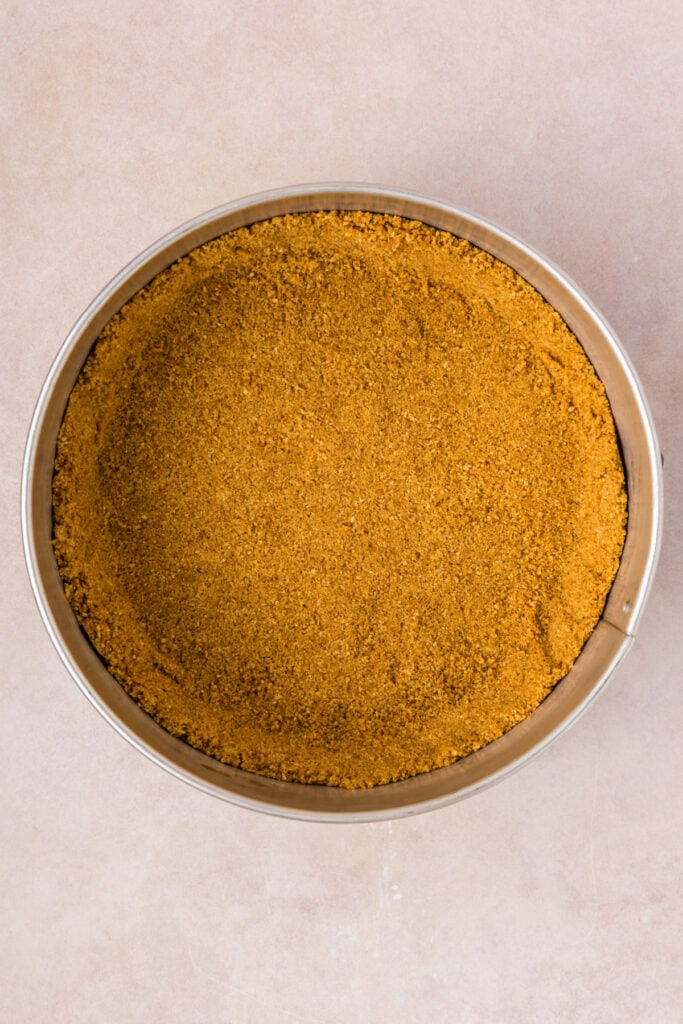 Pressed graham cracker crust in a springform pan, ready to be baked