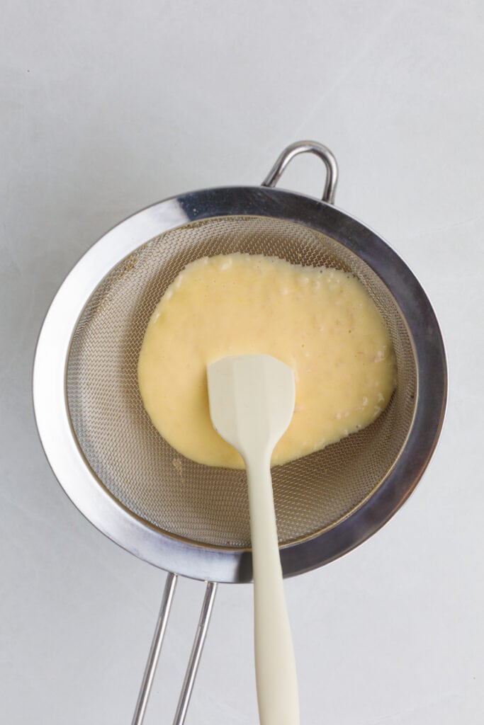 straining the sauce through a wire mesh strainer