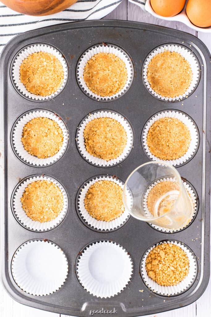 Graham cracker crusts pressed into cupcake liners with a small glass