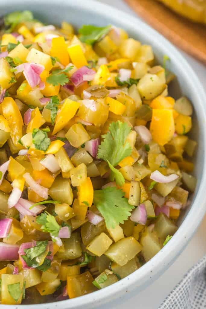 Close-up of Pickle de Gallo in a bowl, highlighting the chopped pickles, peppers, onion, and cilantro.
