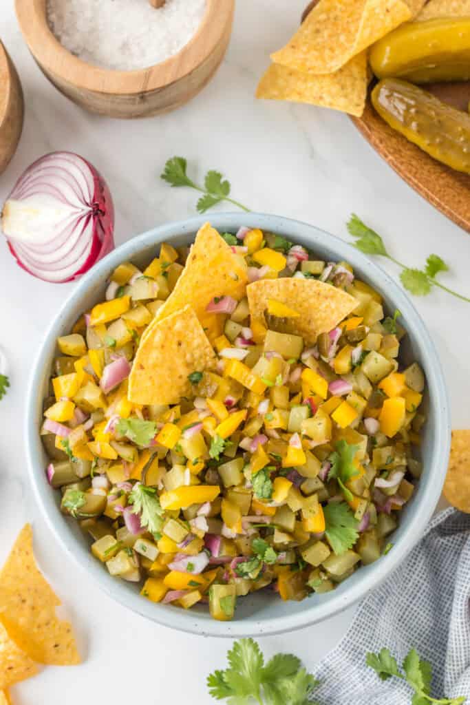 Overhead view of Pickle de Gallo served in a bowl with tortilla chips and garnished with fresh cilantro.