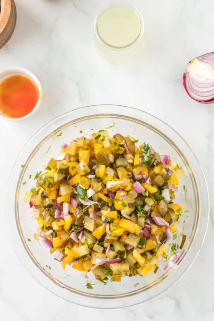 Pickle de Gallo ingredients fully mixed in a clear bowl, showing a colorful combination of diced vegetables and herbs.