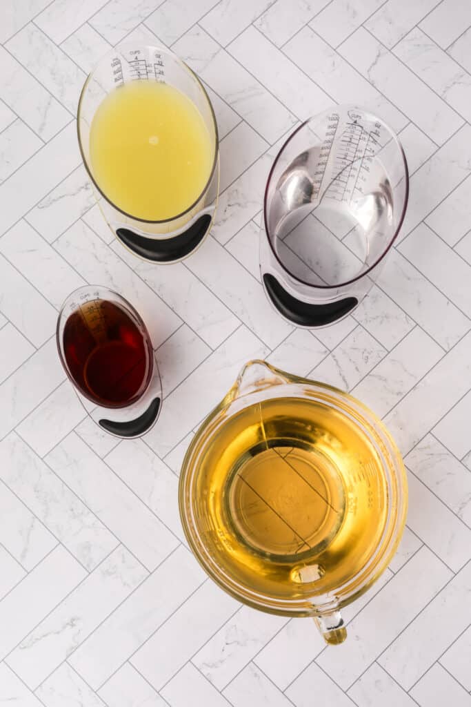 Overhead view of measured ingredients for margaritas including lime juice, tequila, and Cointreau
