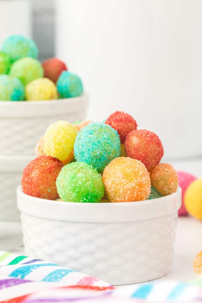 Small white bowl filled with colorful Sour Patch Grapes with a second bowl blurred in the background
