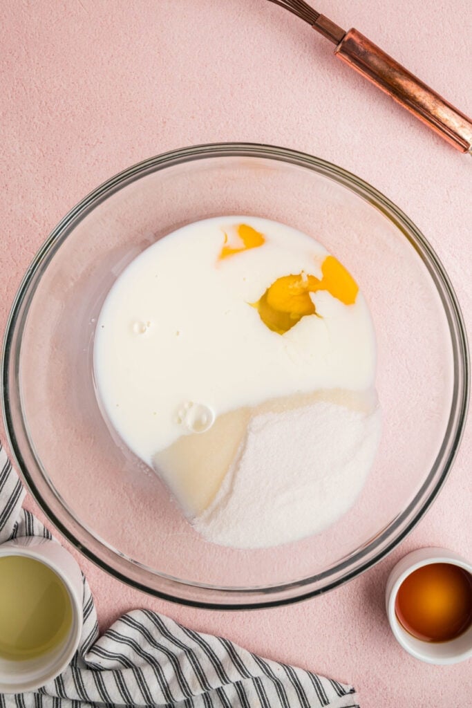Egg, sugar, milk, and vanilla extract in a bowl before mixing wet ingredients