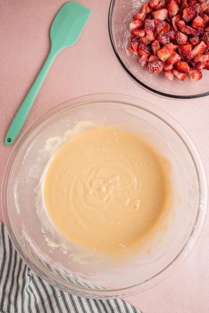 Thick, smooth strawberry bread batter in a glass bowl ready for add-ins