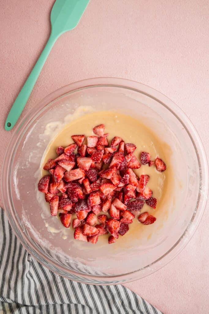 Floured strawberries added on top of batter, ready to be folded in