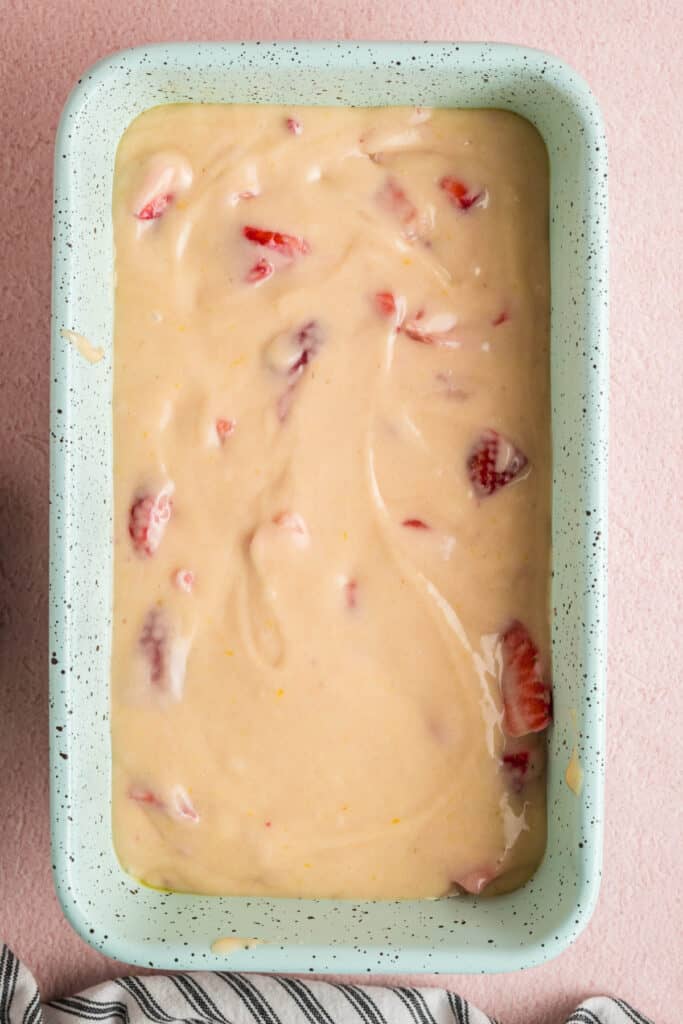 Close-up of strawberry bread batter poured into a speckled loaf pan
