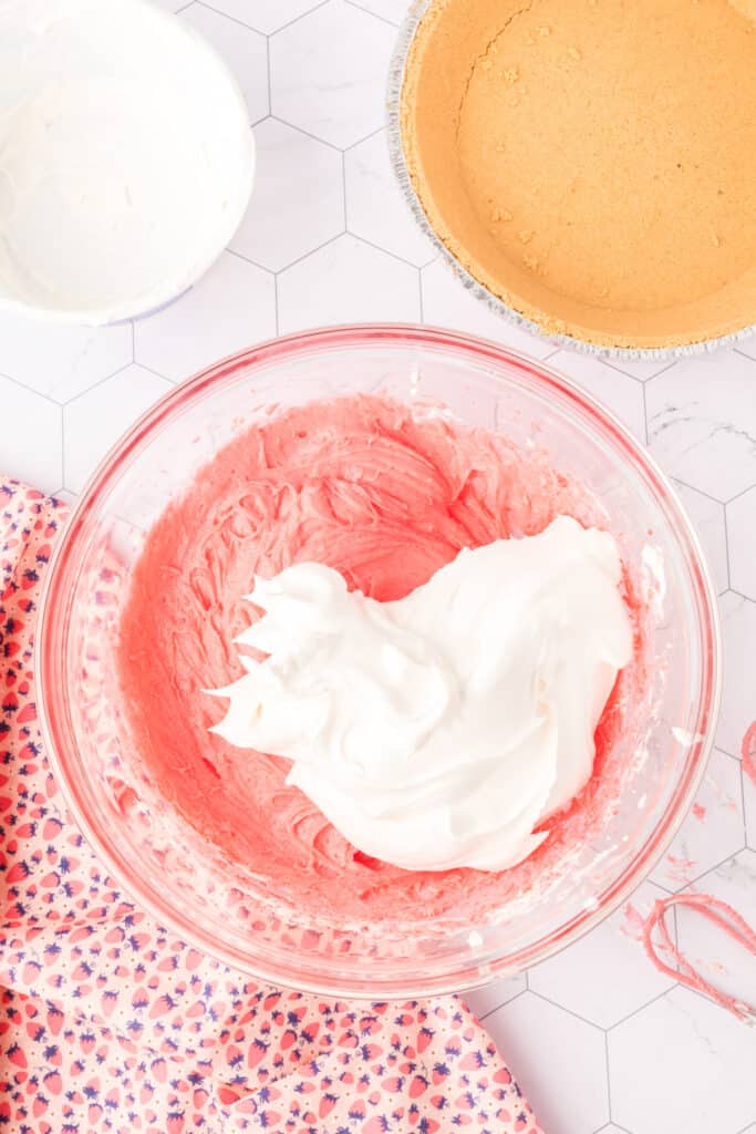 Whipped topping added to the pink strawberry cream cheese mixture before final mixing