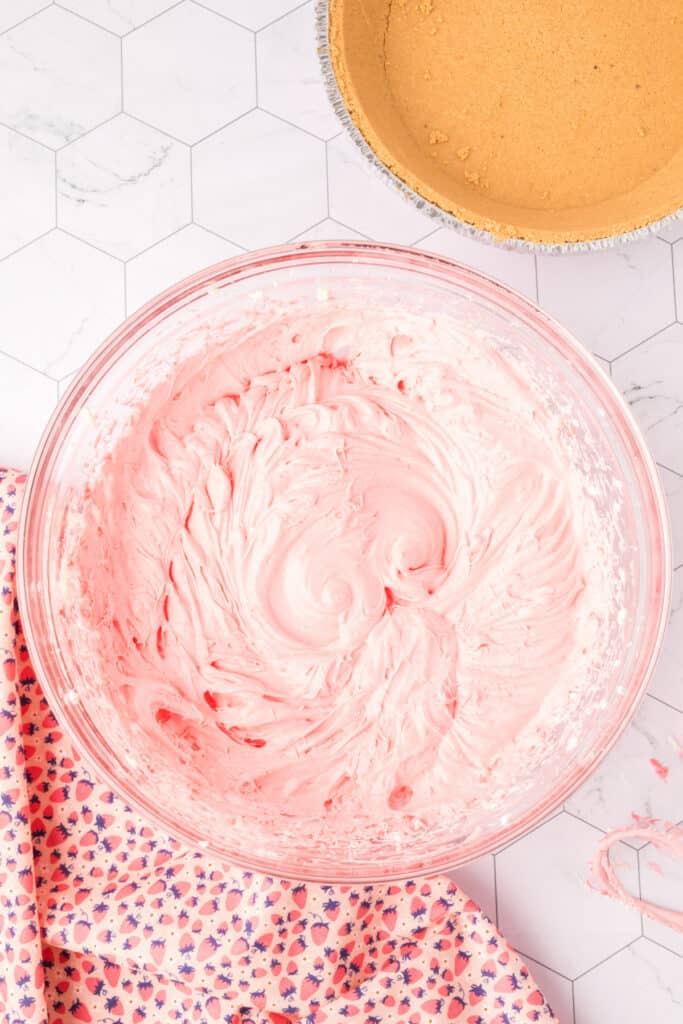 Fully mixed strawberry Jello pie filling in a bowl, smooth and fluffy with a light pink color