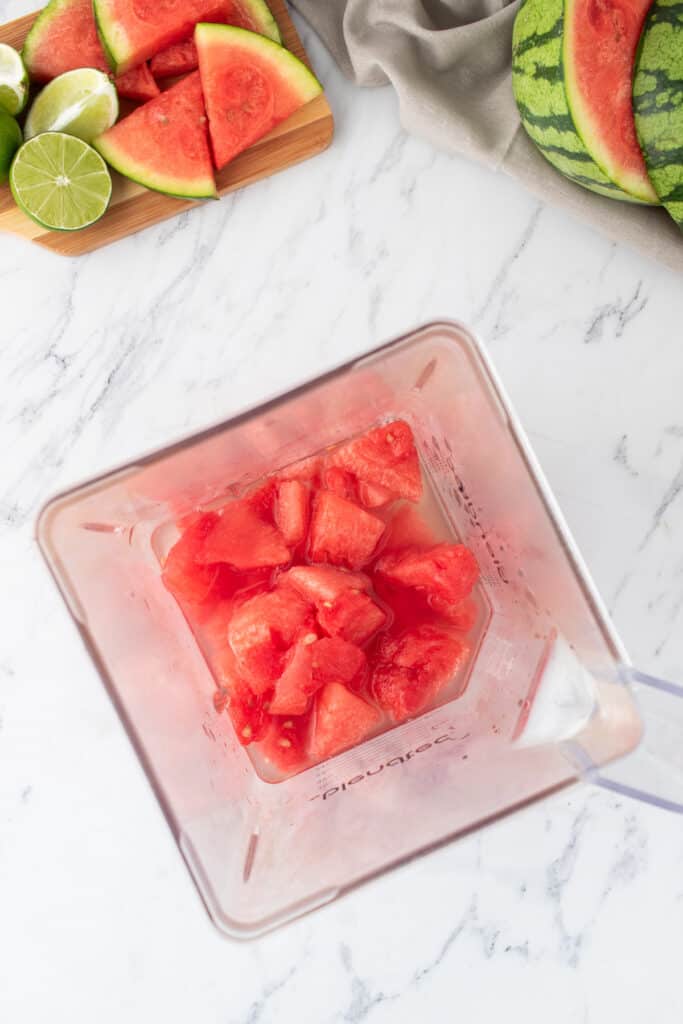Blender filled with fresh watermelon chunks ready to be mixed for margaritas