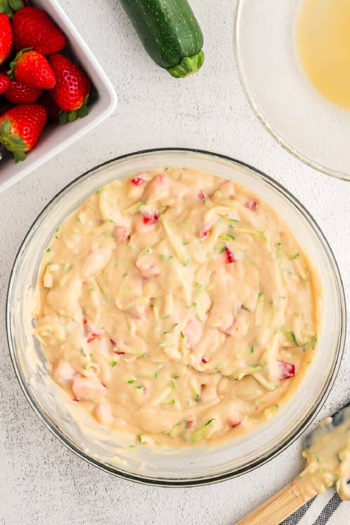 Strawberry zucchini bread batter fully mixed with visible zucchini and strawberry pieces