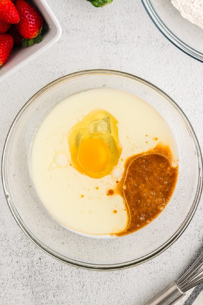 Mixing bowl with buttermilk, egg, oil, and vanilla extract before whisking