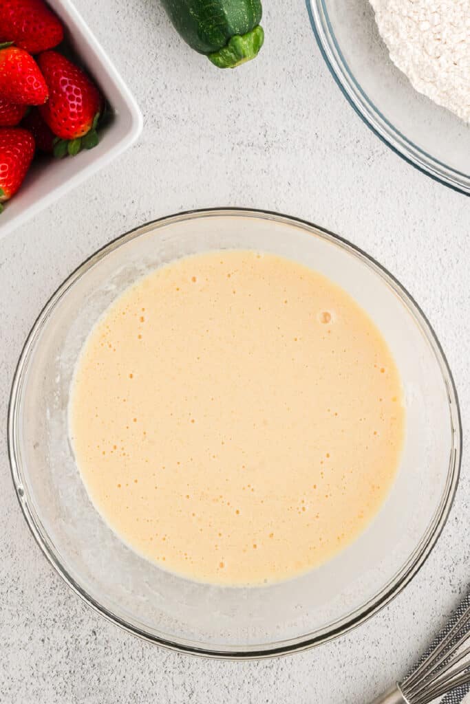Wet ingredients whisked together in a glass bowl until smooth and pale yellow