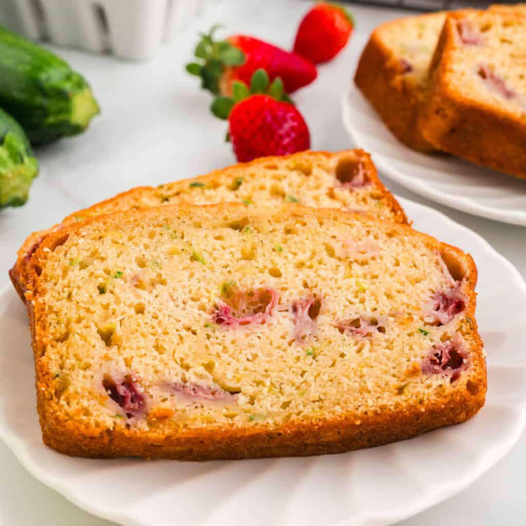 closeup of two slices of strawberry zucchini bread on plate
