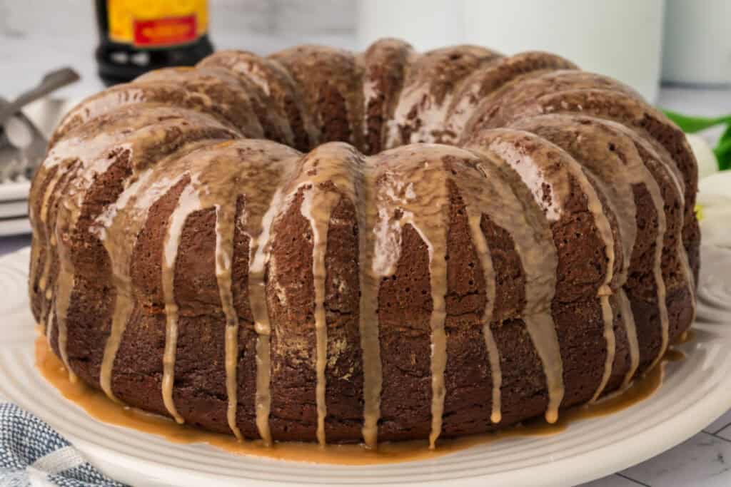 Side view of Chocolate Kahlua Bundt Cake on a platter, showing rich glaze drips.