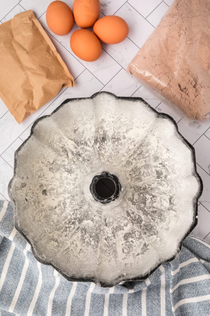 Bundt pan greased and floured with ingredients for Kahlua cake in the background.