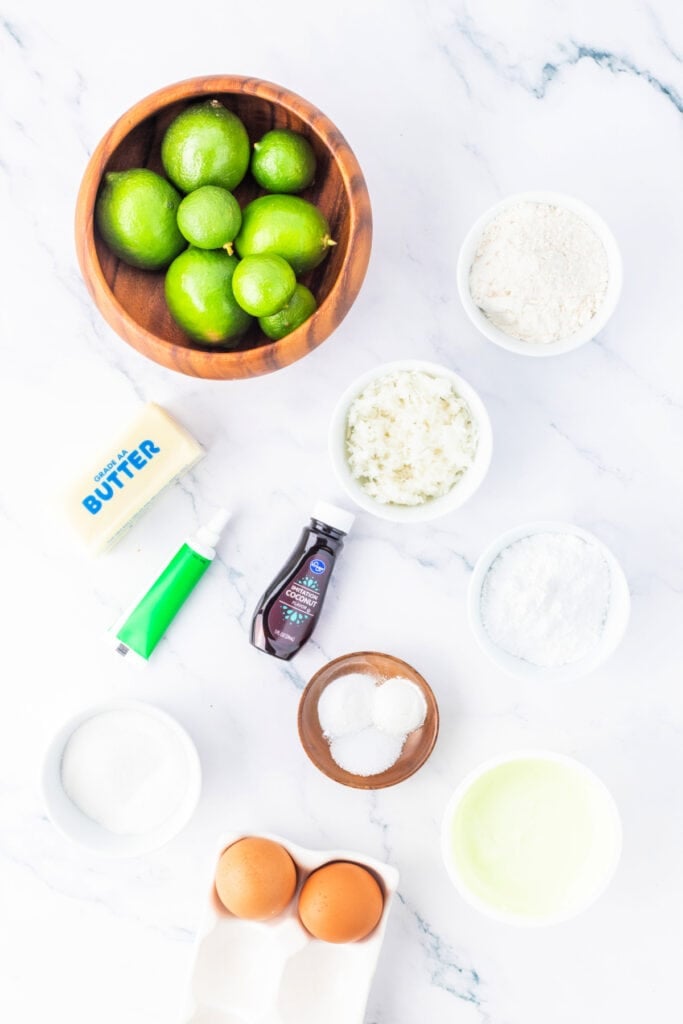 Overhead shot of key ingredients for coconut lime cupcakes arranged on a marble surface