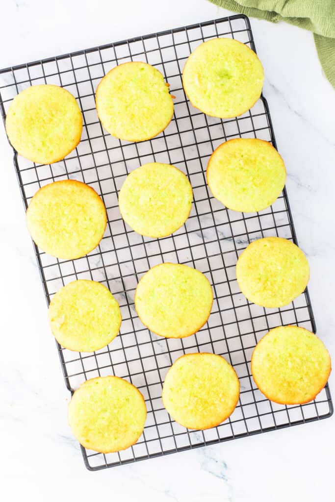Baked coconut lime cupcakes cooling on a wire rack