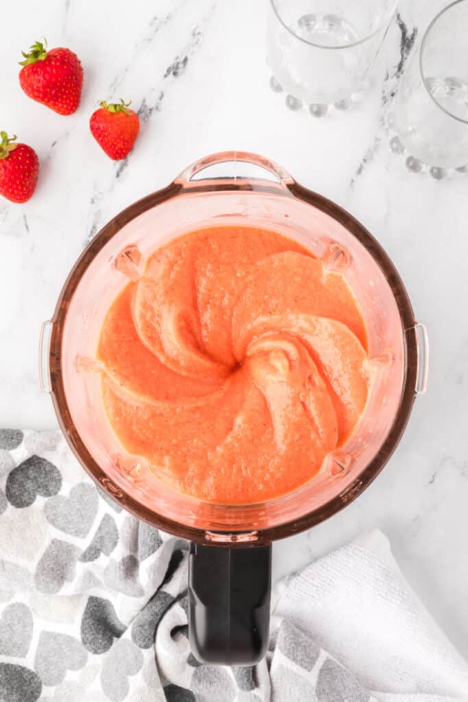 Blended sunrise sunset smoothie mixture in blender, ready to serve.