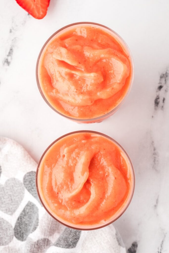 Overhead view of two glasses filled with sunrise sunset smoothie.