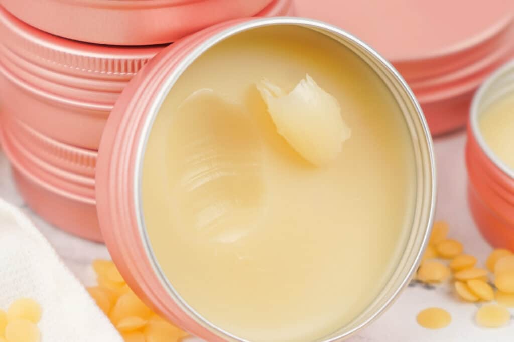 Finished dog paw balm with a smooth surface and a small scoop taken out.