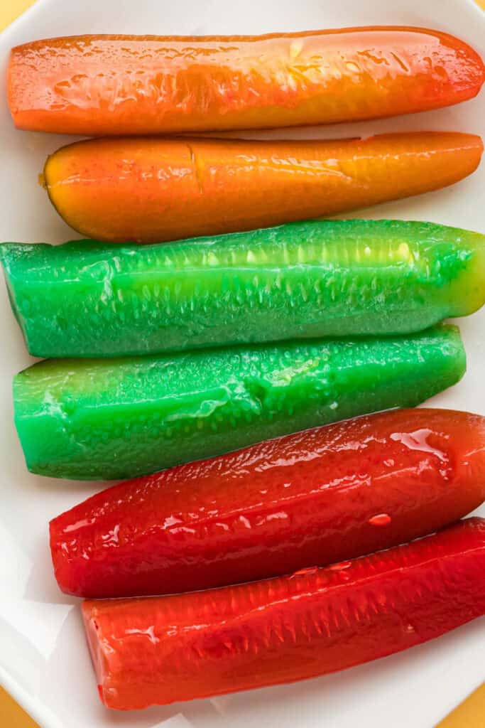 Overhead view of assorted Kool-Aid pickles displayed on a white plate.