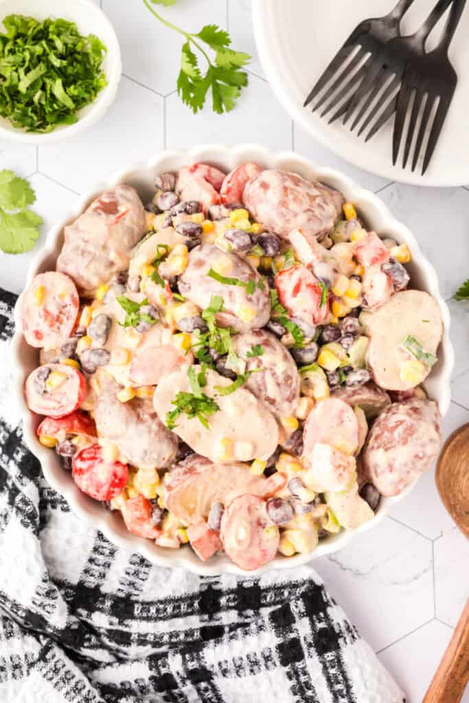 Southwest Potato Salad served in a white scalloped dish, garnished with fresh cilantro.