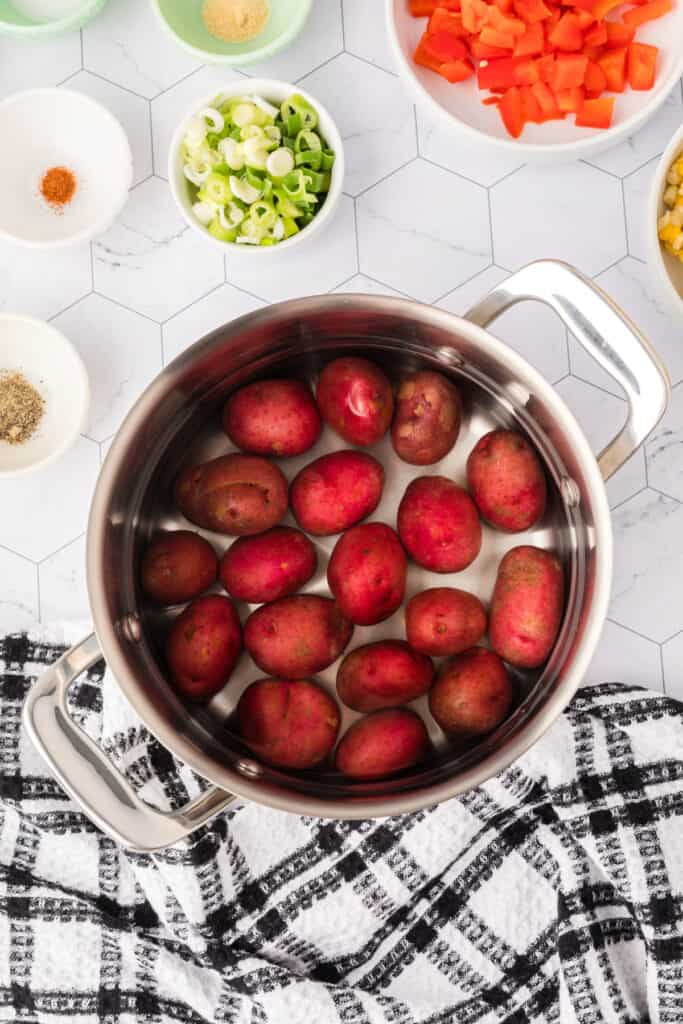 Red potatoes placed in a large saucepan, ready for boiling.