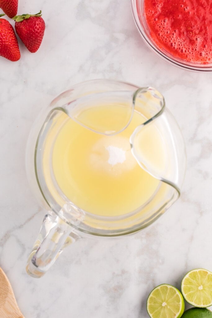 Pitcher with lime juice and sugar mixture, ready to combine with other ingredients.