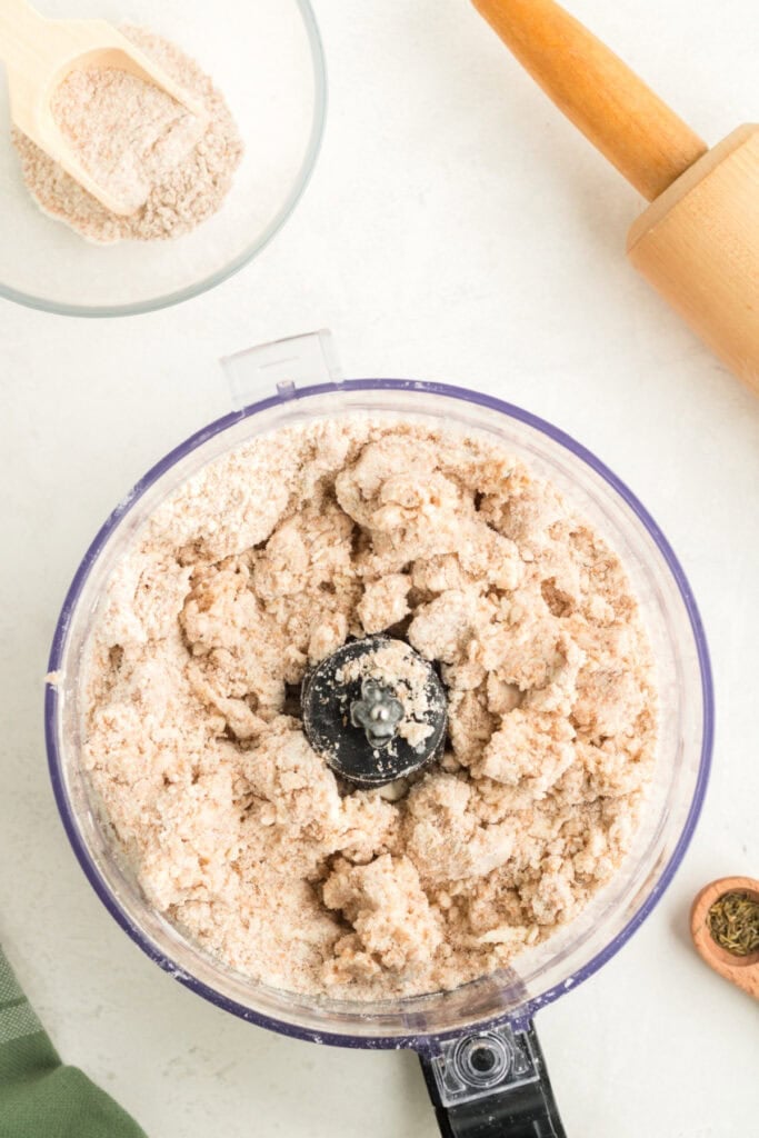 Galette dough forming inside a food processor after adding iced water.