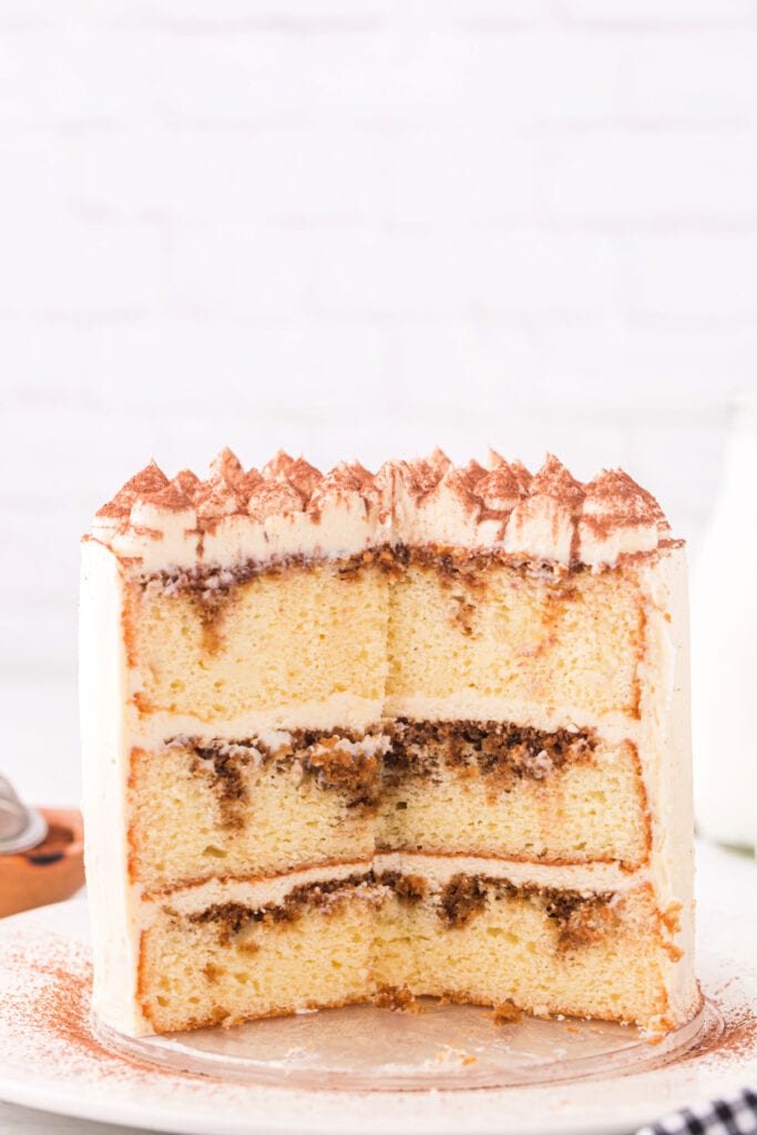 Sliced tiramisu cake showing espresso-soaked layers and creamy mascarpone frosting.