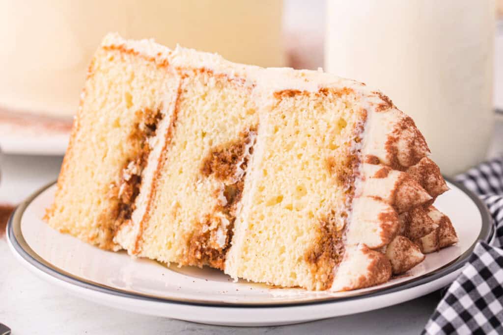 Close-up of a tiramisu cake slice with espresso-soaked layers and creamy frosting.