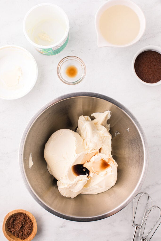 Mixing bowl with mascarpone cheese and vanilla extract before blending.