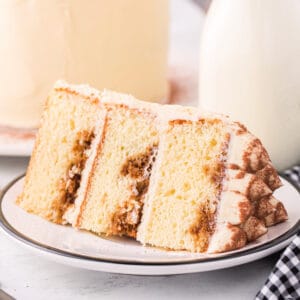 Square cropped image of a tiramisu cake slice showing coffee-soaked layers and mascarpone frosting.
