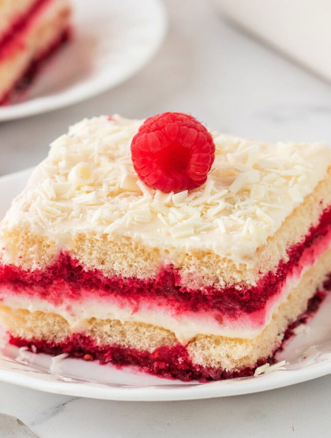 Square image of tiramisu slice topped with a fresh raspberry, perfect for social sharing