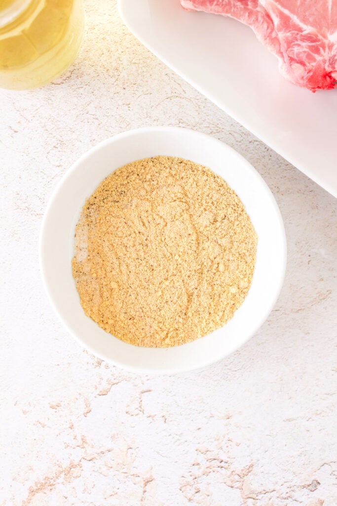 Mixed spice rub in a white bowl ready for seasoning the pork chops
