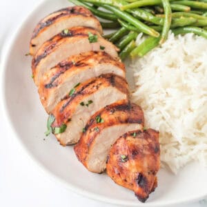 Square image of grilled balsamic chicken breast with white rice and green beans