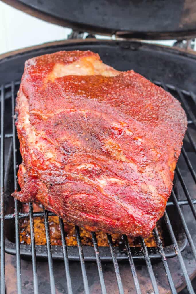 	Close-up of Boston butt developing a mahogany bark halfway through grilling.