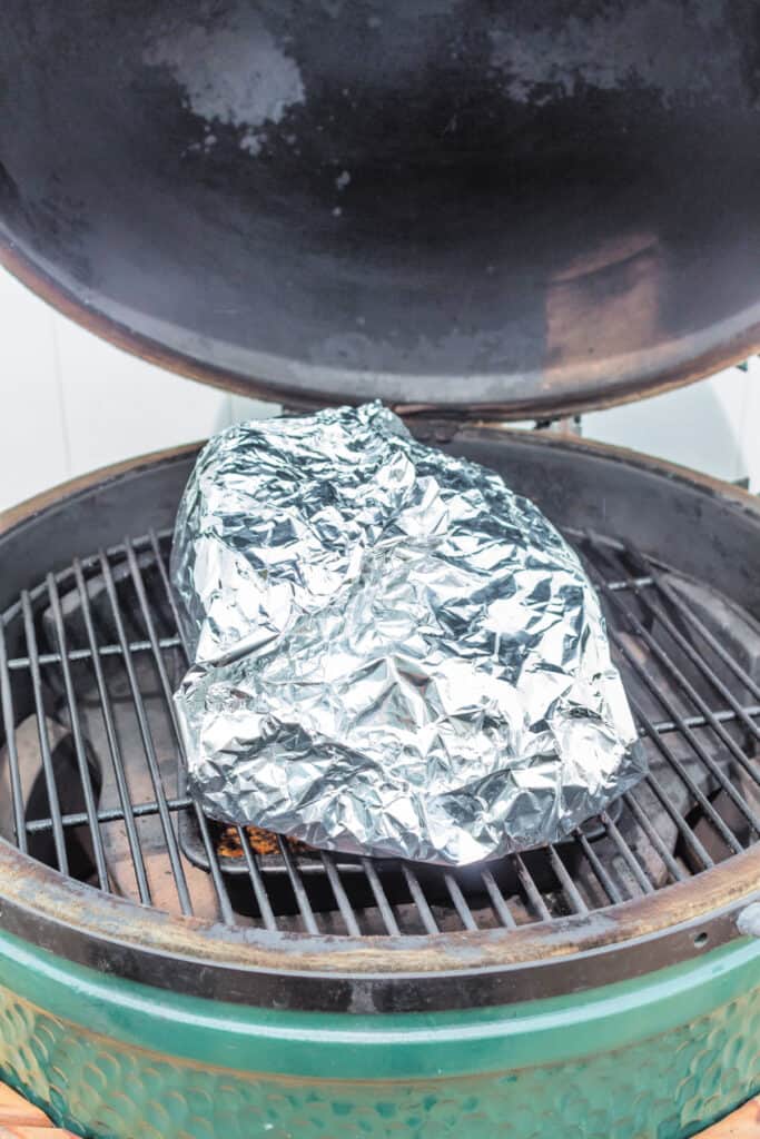 Boston butt tightly wrapped in foil on the grill to finish cooking.